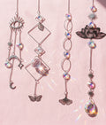 Celestial-inspired hanging sun catchers with reflective crystal-look drops and moon, star, butterfly, lotus, and geometric accents.