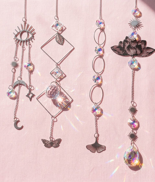 Celestial-inspired hanging sun catchers with reflective crystal-look drops and moon, star, butterfly, lotus, and geometric accents.